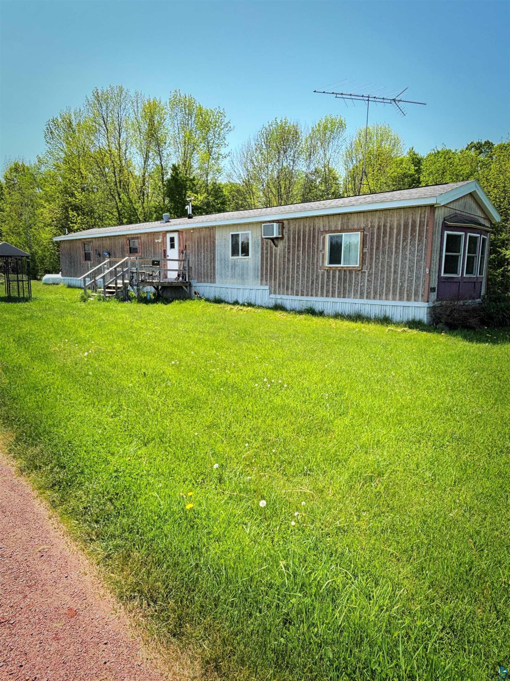 67805 Old County Road High Bridge, WI 54846 - Photo 1 of 11 Single-level residence featuring light-toned vertical siding and a prominent front entrance with wooden steps