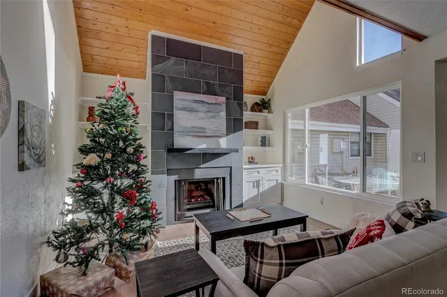 a living room with furniture a potted plant and a fireplace