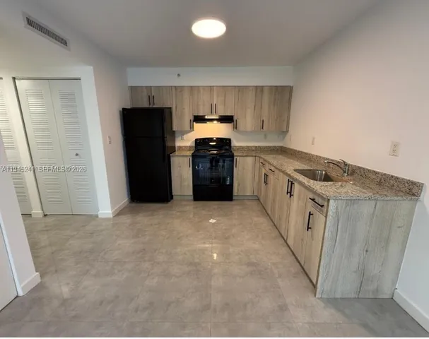 a kitchen with granite countertop a refrigerator and a stove
