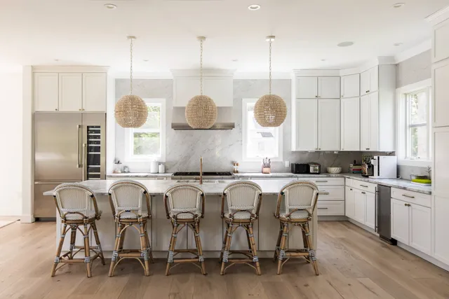 a kitchen with stainless steel appliances granite countertop a table chairs sink and stove top oven
