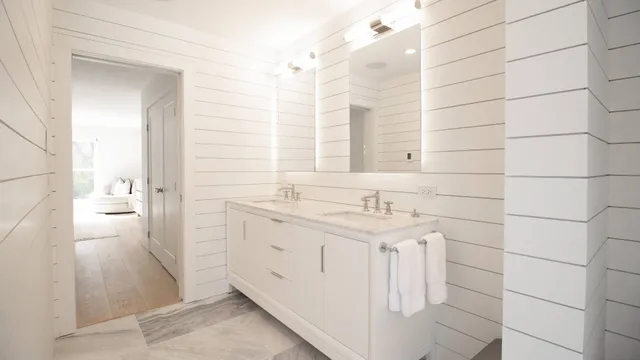 a bathroom with a double vanity sink a mirror and a shower