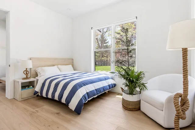 a bedroom with a bed and a potted plant