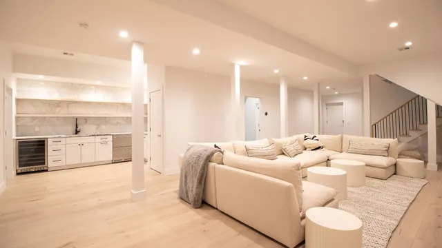 a living room with furniture white walls and kitchen view