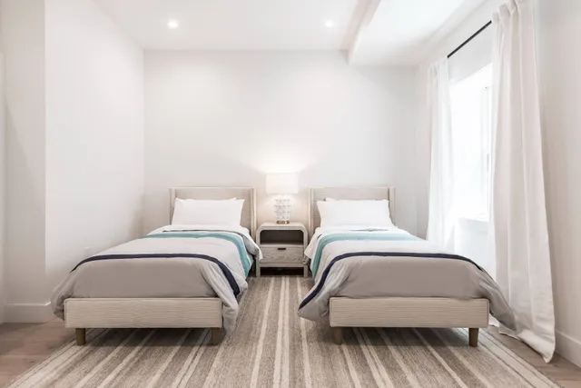 a bedroom with two beds and a chair