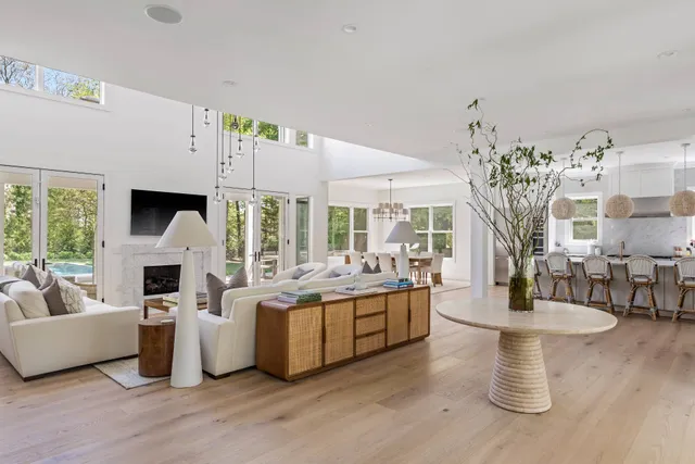 a living room with fireplace furniture and a large window