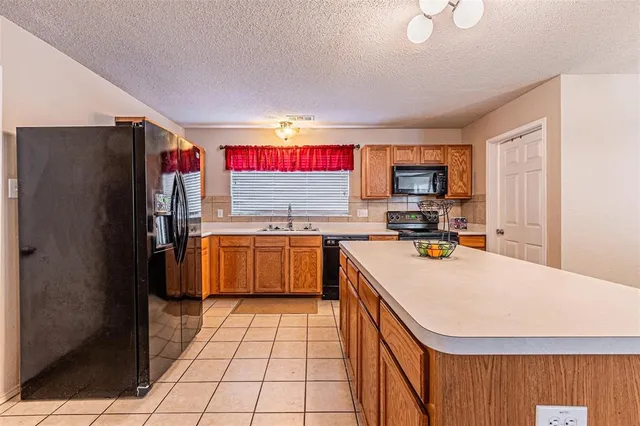 a kitchen with a refrigerator a sink and a counter top