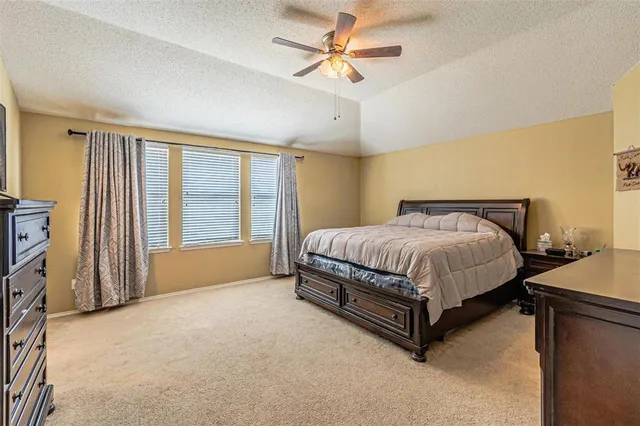 a spacious bedroom with a bed and a chandelier