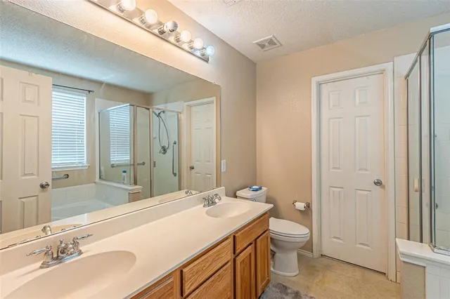 a bathroom with a sink double vanity granite and a toilet