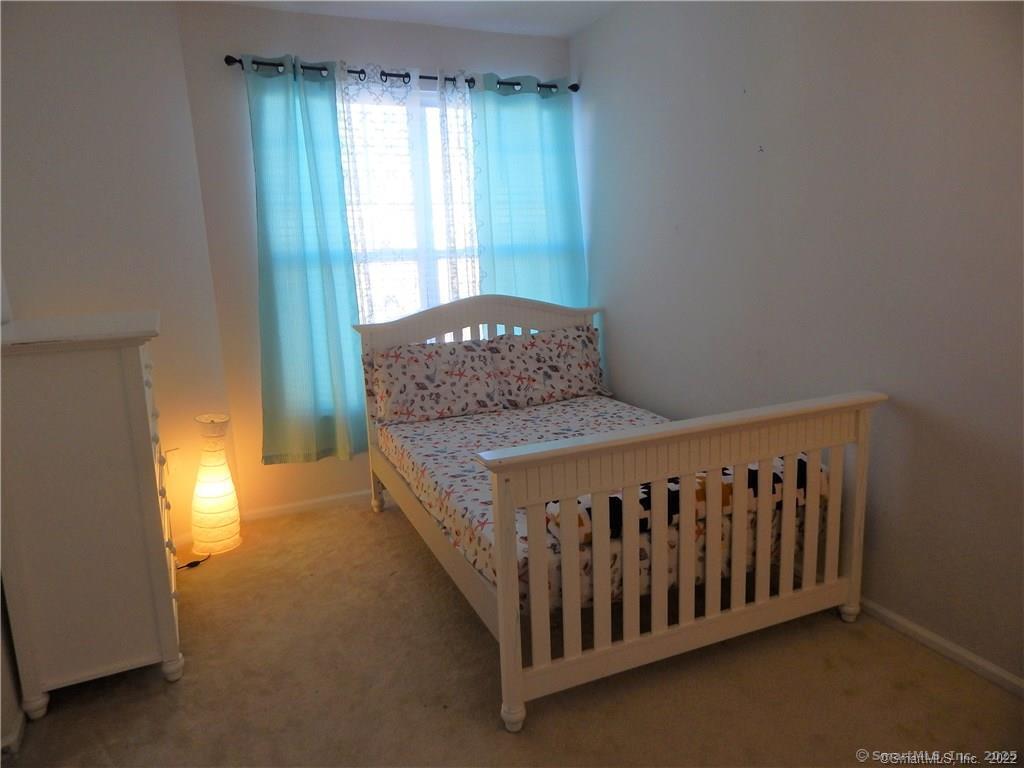 35 West Broad Street, Unit 412 Stamford, CT 06902 - Photo 17 of 35 a bed sitting in a bedroom next to a window