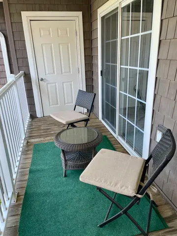 a view of a chair and table in the back yard of the house