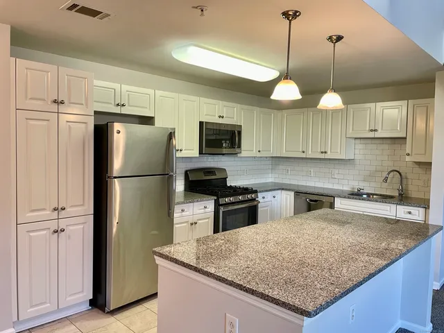a kitchen with refrigerator a sink and a microwave