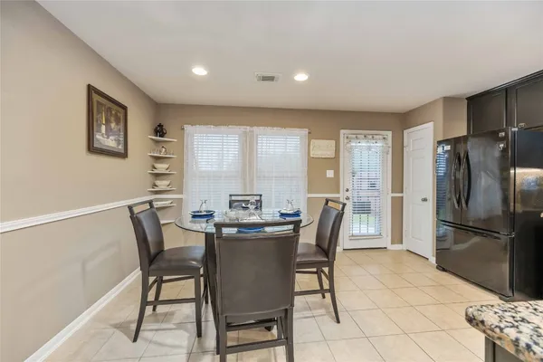 a view of a dining room with furniture and a refrigerator