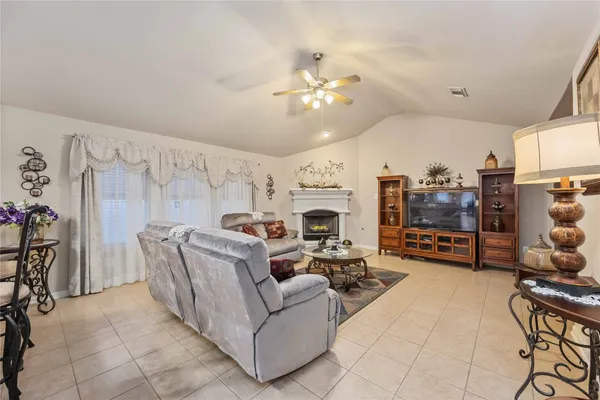 a living room with furniture a fireplace and a chandelier