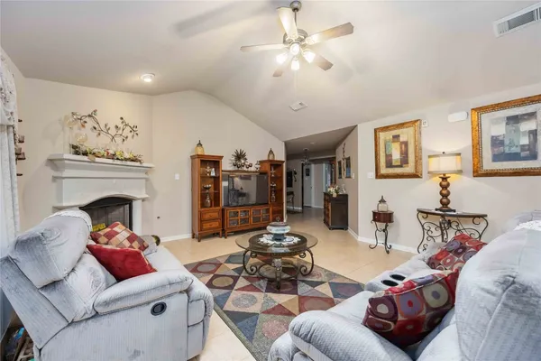 a living room with furniture a fireplace and a chandelier