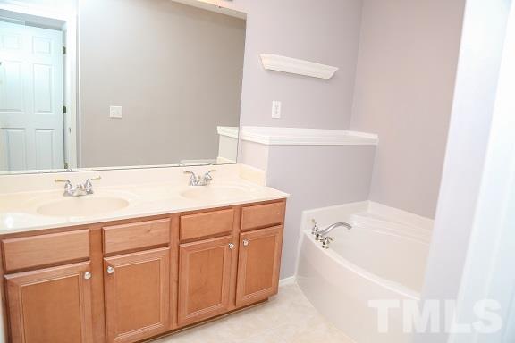 8312 Chimneycap Drive Raleigh, NC 27613 - Photo 19 of 25 a bathroom with a tub sink and mirror