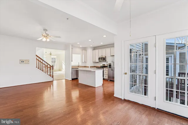 a view of kitchen with kitchen island wooden floor and refrigerator