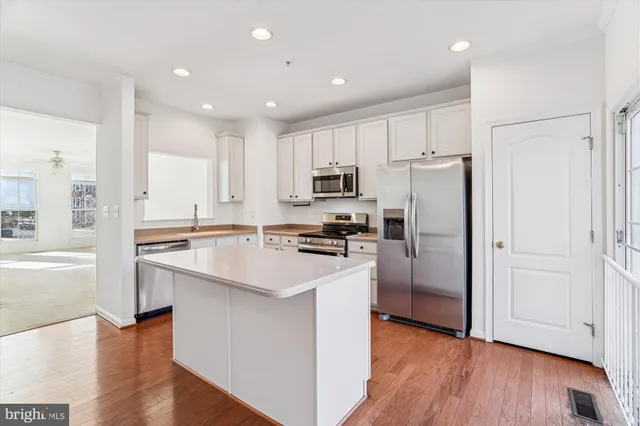 a kitchen with a refrigerator a sink and a stove top oven