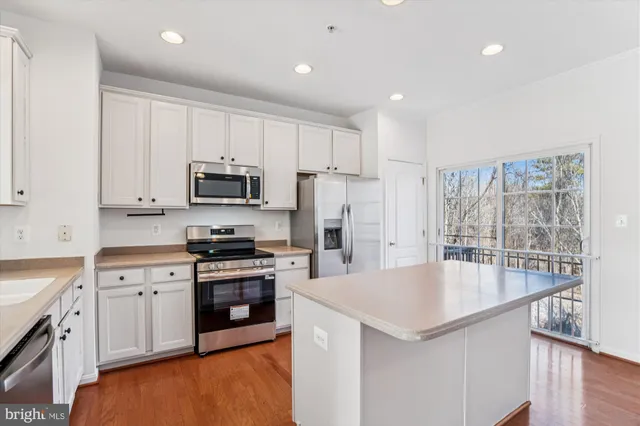 a kitchen with kitchen island a sink stove and refrigerator