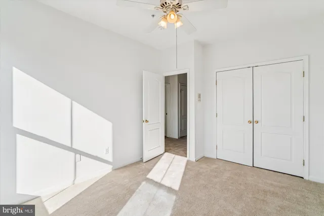 a view of a room with a ceiling fan and entryway