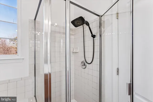 a bathroom with a glass shower door and a shower