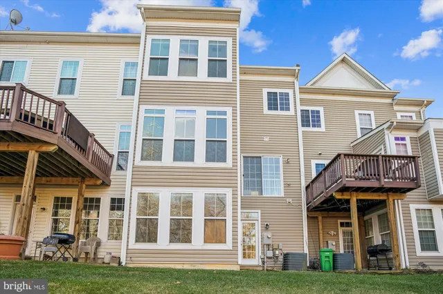 a view of a brick building with many windows and a yard