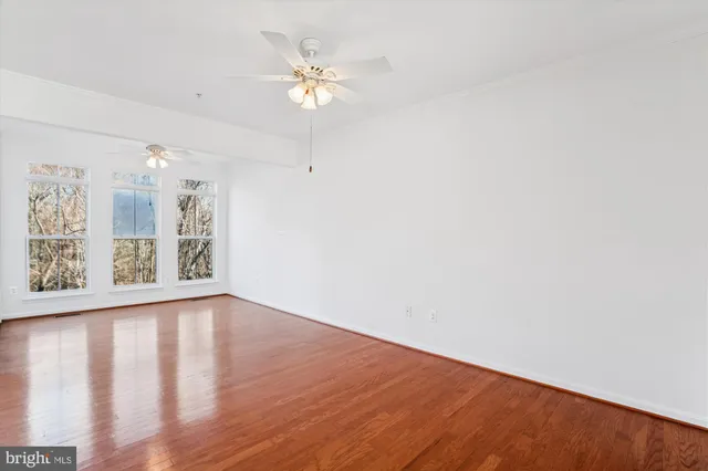 an empty room with wooden floor and window