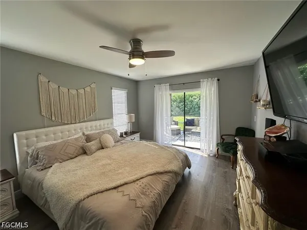 a spacious bedroom with a bed a window and a flat screen television