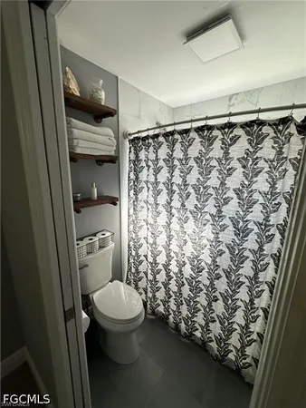 a bathroom with a toilet and a shower curtain