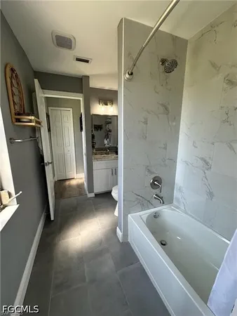 a bathroom with a tub a sink and a large mirror