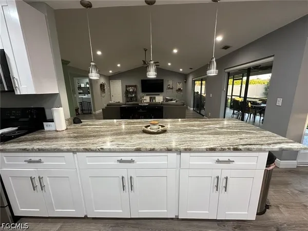 a kitchen with stainless steel appliances granite countertop a stove a sink and a microwave