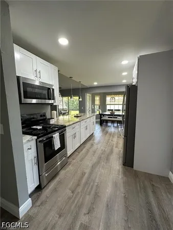 a kitchen with stainless steel appliances kitchen island granite countertop a stove and a refrigerator