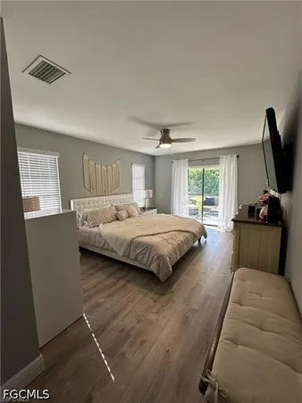 a spacious bedroom with a bed and wooden floor