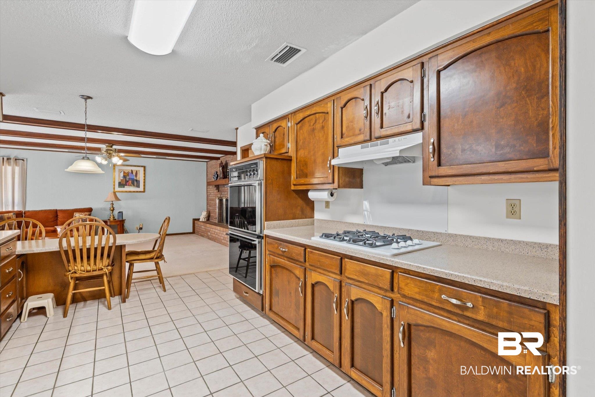 1900 Foxfire Road Mobile, AL 36618 - Photo 12 of 36 Kitchen featuring pendant lighting, light tile patterned floors, a textured ceiling, under cabinet range hood, and white gas stovetop