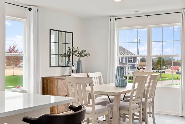 a dining room with furniture a rug and a large window