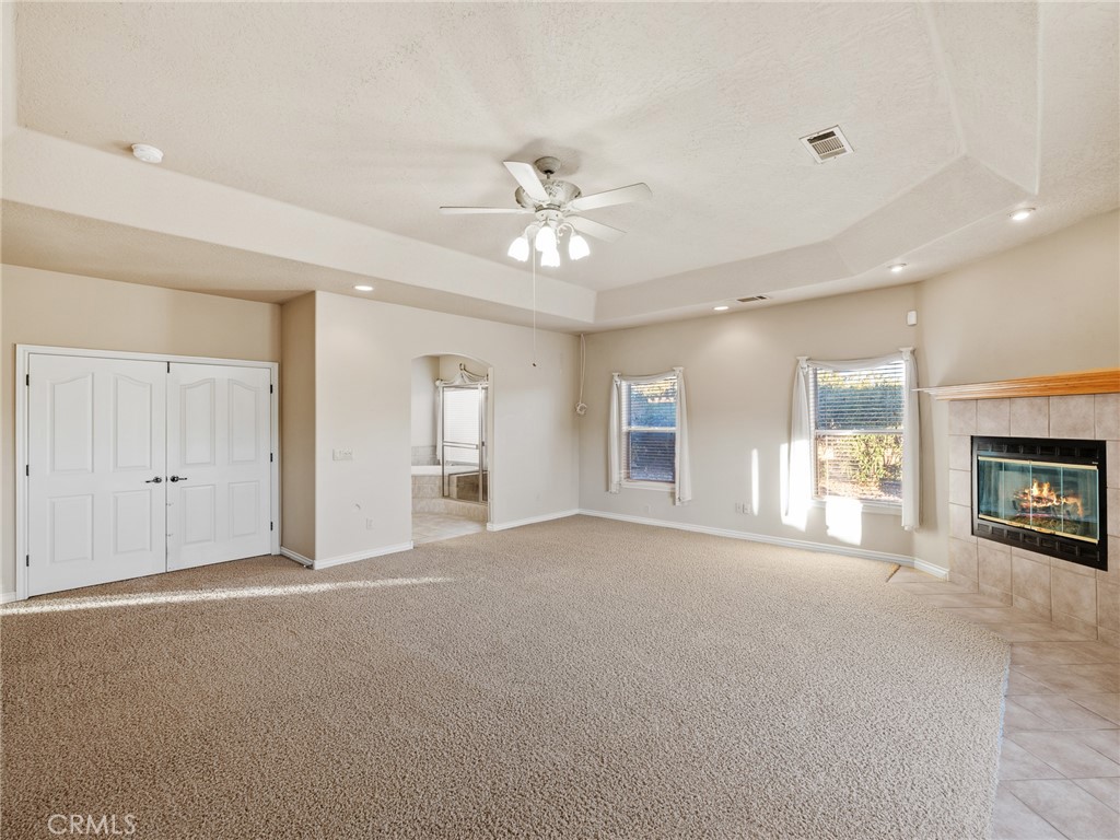 11385 Oak Ridge Drive Oak Hills, CA 92344 - Photo 21 of 69 a view of a livingroom with a fireplace a ceiling fan and windows