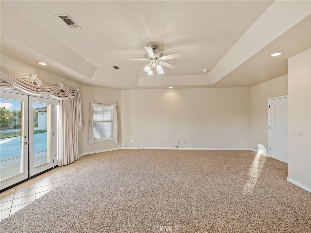 11385 Oak Ridge Drive Oak Hills, CA 92344 - Photo 30 of 69 an empty room with chandelier fan and windows