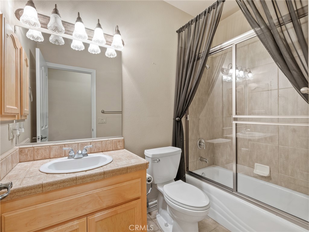 11385 Oak Ridge Drive Oak Hills, CA 92344 - Photo 32 of 69 a bathroom with a sink a toilet a mirror and a shower
