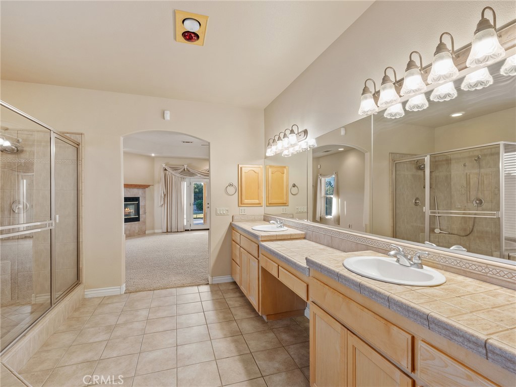 11385 Oak Ridge Drive Oak Hills, CA 92344 - Photo 33 of 69 a spacious bathroom with a granite countertop sink a large mirror and a shower