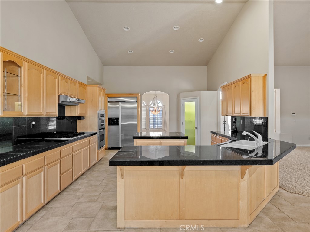 11385 Oak Ridge Drive Oak Hills, CA 92344 - Photo 35 of 69 a large kitchen with granite countertop a sink a stove and cabinets