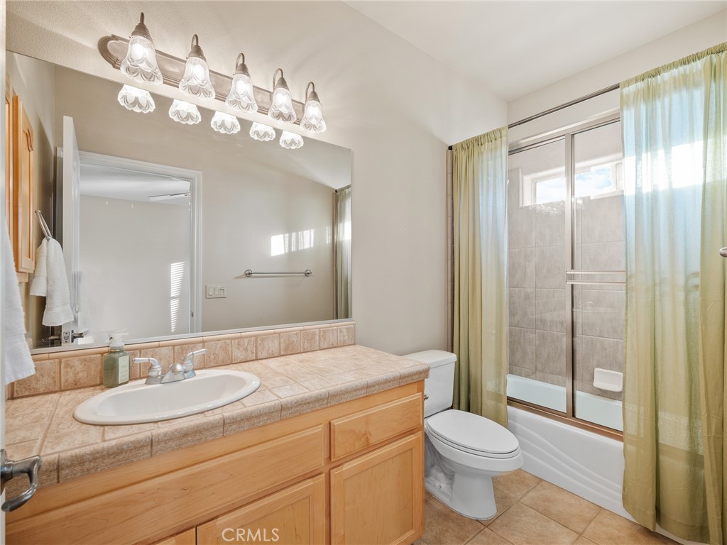 11385 Oak Ridge Drive Oak Hills, CA 92344 - Photo 49 of 69 a bathroom with a toilet a sink and mirror