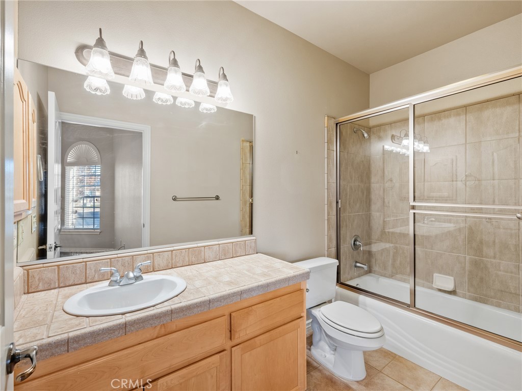 11385 Oak Ridge Drive Oak Hills, CA 92344 - Photo 53 of 69 a spacious bathroom with a granite countertop sink toilet a mirror and shower