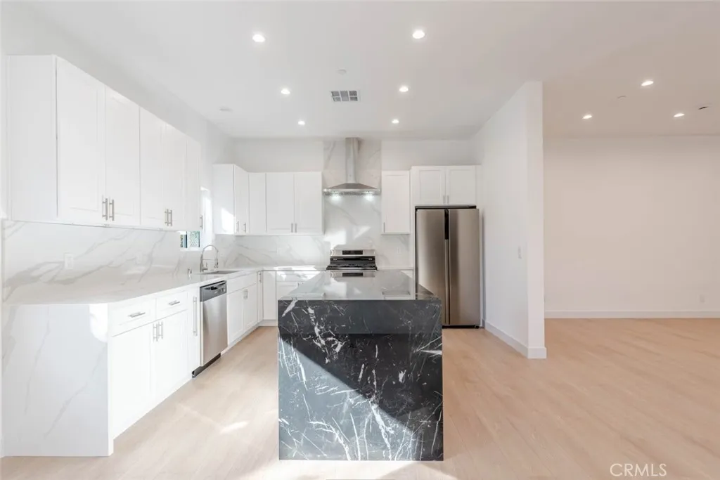 6850 Ranchito Avenue Van Nuys, CA 91405 - Photo 10 of 23 a large kitchen with stainless steel appliances kitchen island granite countertop a refrigerator and a sink