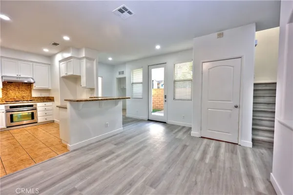 a kitchen with stainless steel appliances granite countertop a refrigerator and a stove top oven