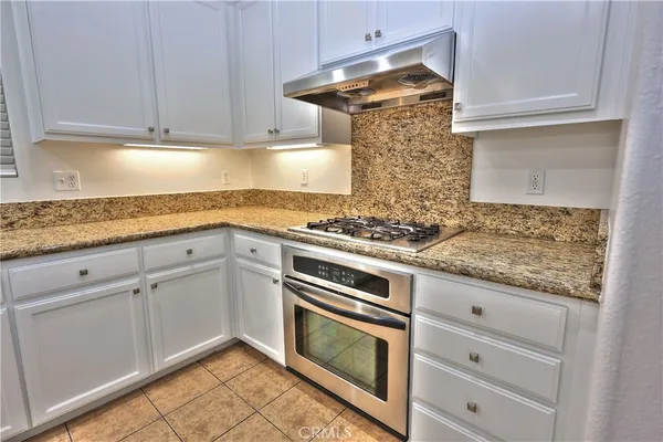 a kitchen with granite countertop cabinets stainless steel appliances and a counter space