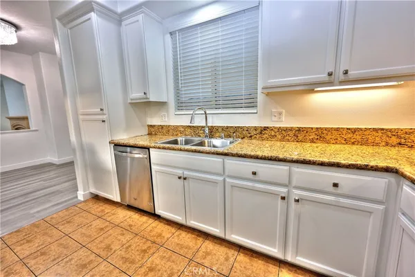 a kitchen with granite countertop white cabinets and white appliances