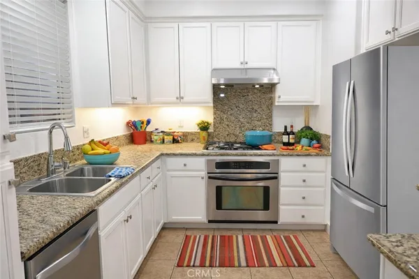 a kitchen with white cabinets and stainless steel appliances