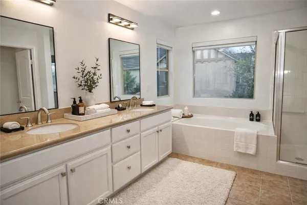 a bathroom with a tub a sink and mirror