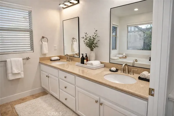 a bathroom with double vanity sinks and a mirror
