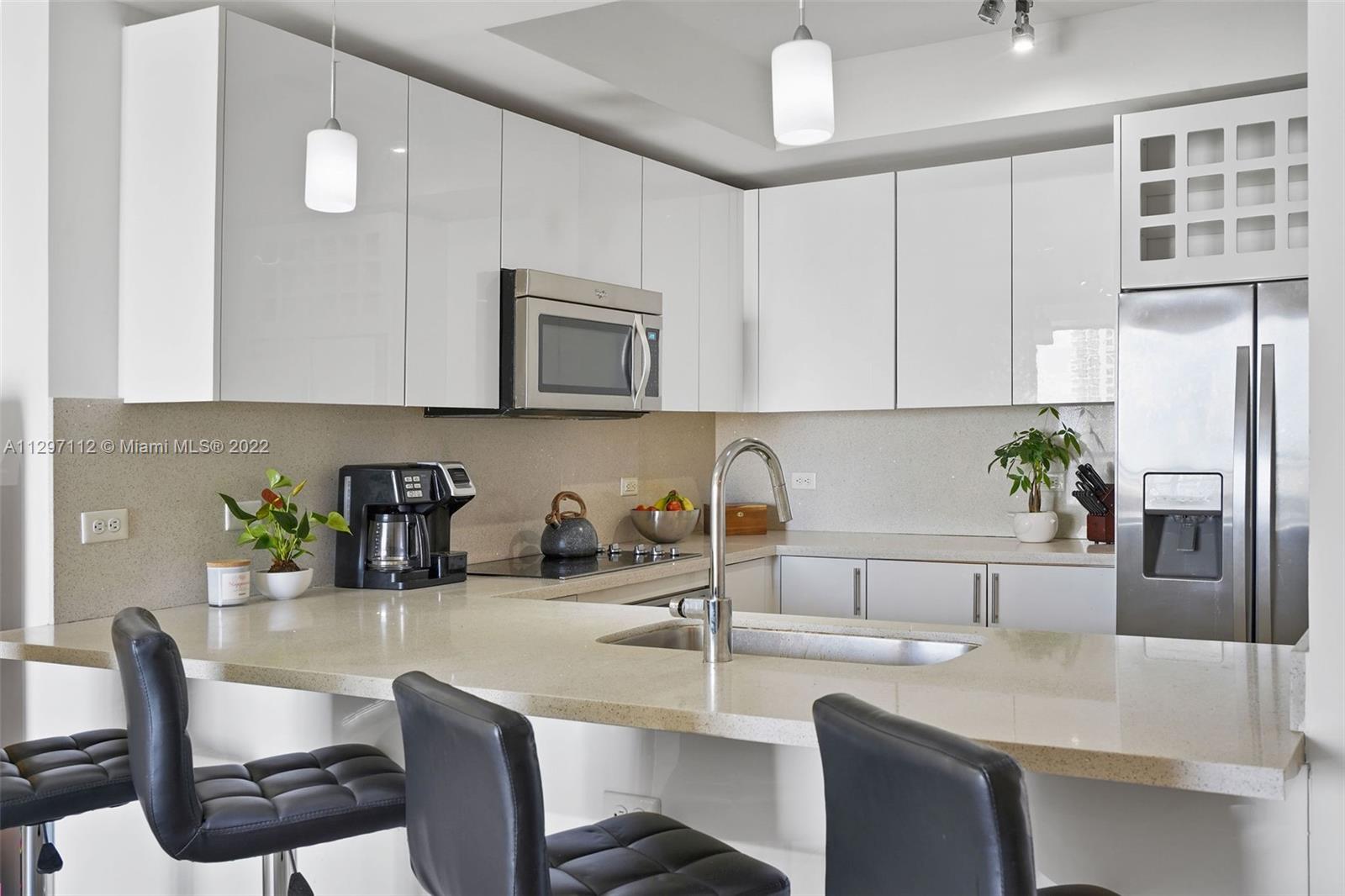 999 Southwest 1st Avenue, Unit 2717 Miami, FL 33130 - Photo 2 of 93 a kitchen with stainless steel appliances granite countertop a sink a stove a microwave a refrigerator a counter space and cabinets