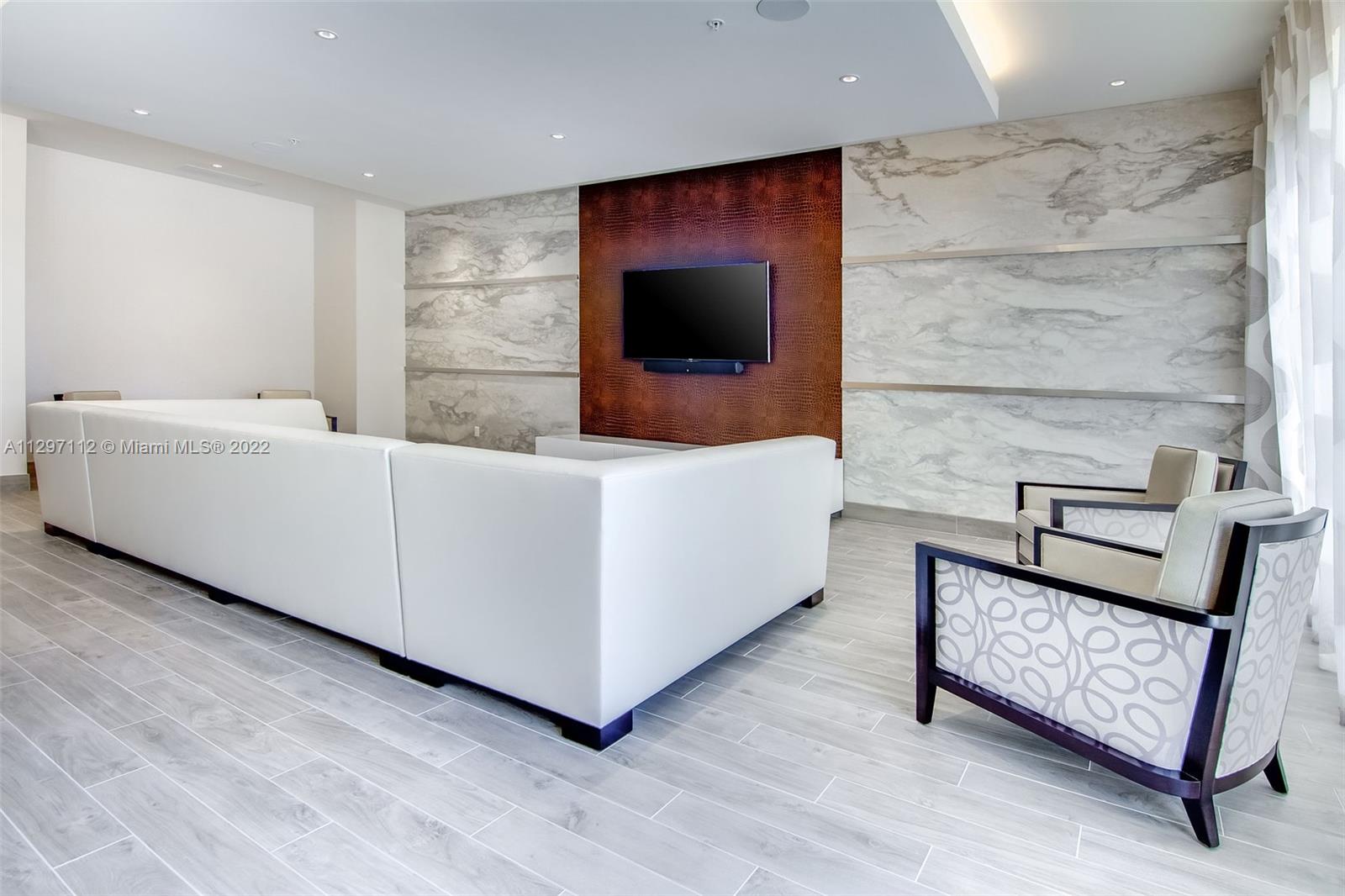 999 Southwest 1st Avenue, Unit 2717 Miami, FL 33130 - Photo 32 of 93 a living room with furniture and a flat screen tv